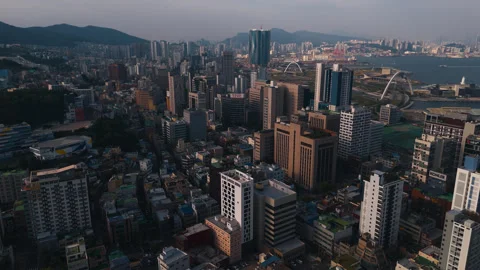 Wide drone shot over Jung-gu district skyscrapers and ocean port in Busan Stock Footage 346854282