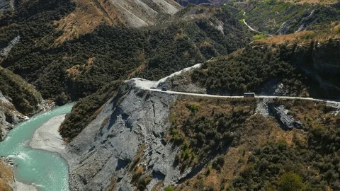 Wide drone shot van driving down mountain road beside river, New Zealand Stock Footage 90267761
