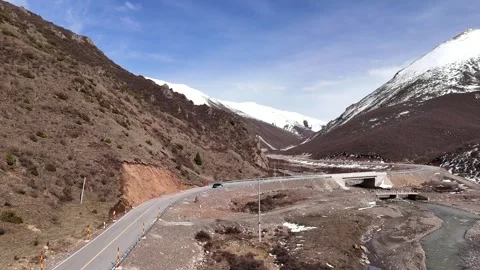 Wide drone view of mountain road crossing rugged terrain in China Stock Footage 337900190