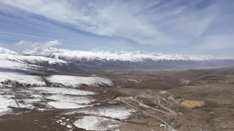 Wide drone view of mountain road crossing rugged terrain in China Stock Footage 337900259