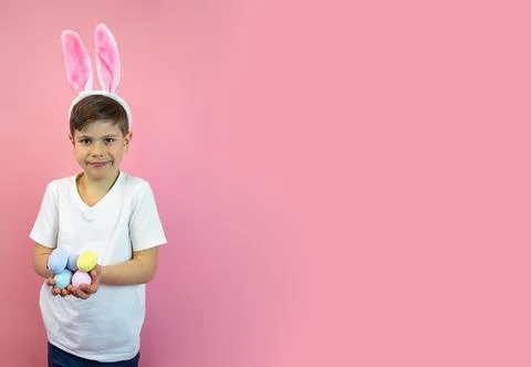 Wide Easter banner.A boy in the ears of a hare holds eggs in his hands. Stock Photos