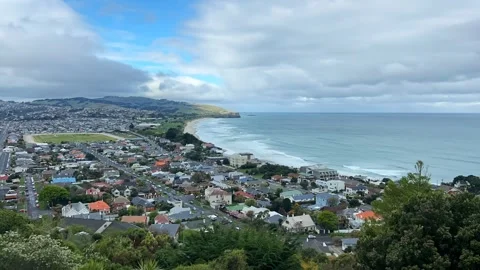 Wide elevated time lapse over Dunedin's southern suburbs and ocean beach Видео 333148735
