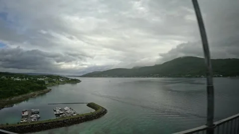 Wide elevated view over boat harbor, turquoise bay, and fjord in Senja Norway Stock-Footage 342340380