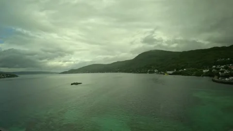 Wide elevated view over marina, turquoise water, and mountains in Senja Norway Vidéo 342340378