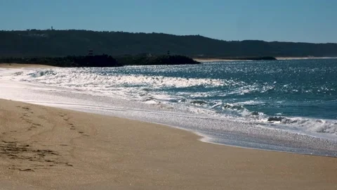 Wide empty, lonely sand beach big waves Atlantic ocean sea mountains lighthouses Stock Footage 273795416
