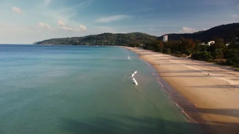 Wide empty phuket beach at dawn with gentle waves and single distant walker Stock Footage 344086476