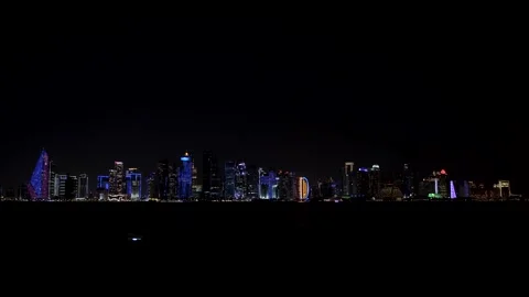 A wide, expansive panoramic shot of the Doha, Qatar skyline at night. The iconic Stock-Footage 336694404