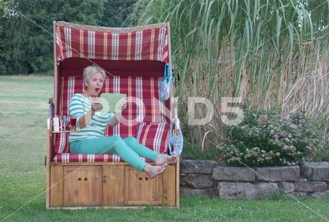 Wide-eyed and terrified, the woman on the tablet reads the junk-e-mail Stock Photos