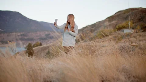 Wide of female content creator taking social media story, talking to camera 库存影片 209351507
