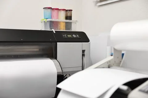 Wide-format printer and roll laminator with paper indoors, selective focus... Fotos de archivo