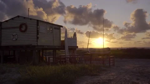 Wide forward moving shot of a small beach pavilion at sunset. Stock-Footage 135612360