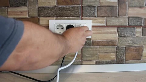 Wide frame of triple power wall socket being plugged and unplugged with 動画素材 141169531