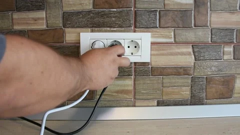 Wide frame of triple power wall socket being plugged and unplugged with 動画素材 141169559