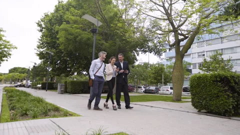 Wide full body view of three coworkers looking at smartphone screen while Stock Footage 277975144
