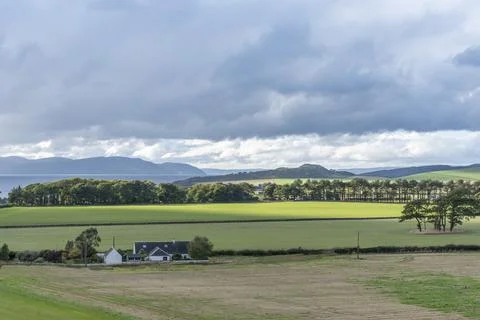 Wide green fields stretch under a cloudy sky Foto stock