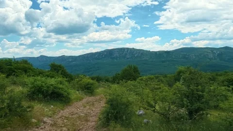 Wide green hills stretch under blue skies. Kozji Kamen area, Serbia Видео 341874826