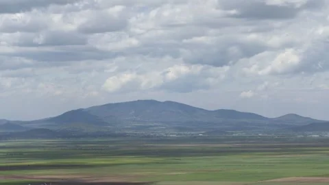 Wide, Green Plain with Clouds leaving speckled effect Stock Footage 314346882