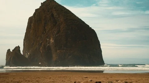 Wide of Haystack Rock on Cannon Beach with Waves crashing Stock Footage 102418024