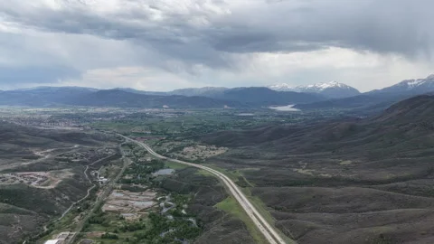 Wide high aerial of Wasatch Range and Highway 189 near Park City Utah in spring Stock Footage 335800196