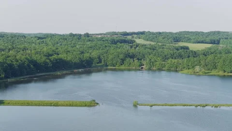 A wide, high-angle aerial shot of Lac du Bourdon in France, showing calm blue Stock Footage 346678387