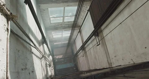 Wide high angle handheld tilt up an old industrial freight elevator shaft. Video stock 138608330