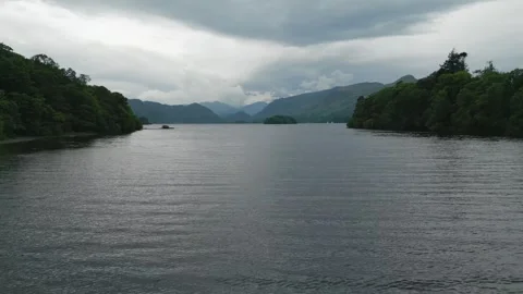 Wide lake stretches under cloudy, moody sky Vidéo 345527520