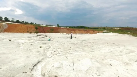 Wide landscape of abandoned white kaolin clay quarry with distant person walking Stock Footage 344812272