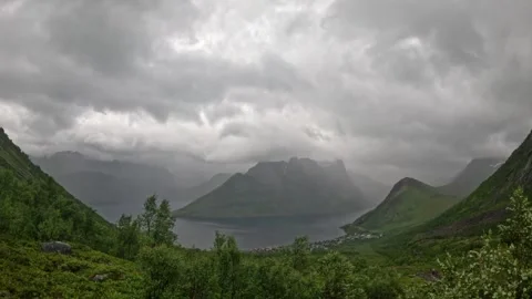 Wide landscape view of dramatic misty fjord valley and village in Senja Norway Vidéo 342059366