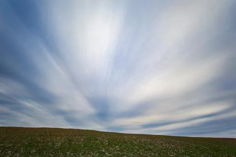 Wide landscape view featuring a gently sloping green field in the foreground Foto stock