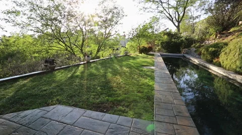 WIDE ON LAP POOL AND POP-UP SPRINKLERS WATERING GRASS LAWN Stock Footage 67640863