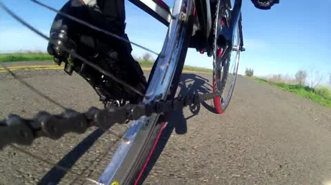 WIDE LOW ANGLE POV OF CYCLIST BIKE WHILE RIDING BICYCLE ON COUNTRY ROAD HD	 Stock Footage