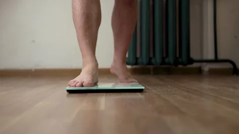Wide Low Angle Shot of Person Using Weight Scale at Home Vidéo 340219953