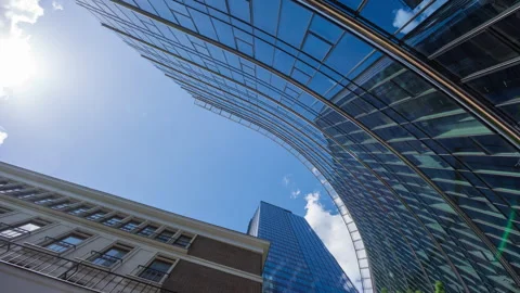 Wide low angle time-lapse of financial district glass skyscrapers and blue sky Stock Footage 337647488