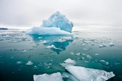 Wide low angle view of melting sea ice floes and iceberg and glacier Stock Photos