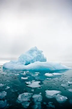 Wide low angle view of melting sea ice floes and iceberg  Stock Photos
