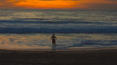 Wide man silhouetted from beach sunset Stock Footage 60733555