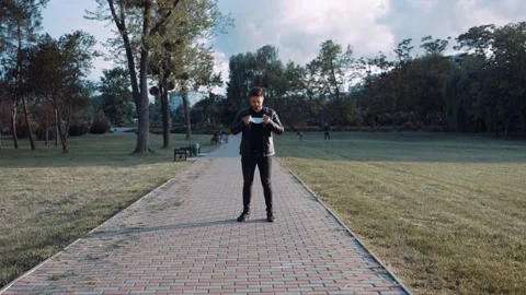 A wide open angle with a personality dressed in black with a mask in the park. Video stock 131664038