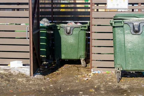 Wide open new garbage dump, with garbage cans out and garbage is around it 스톡 사진