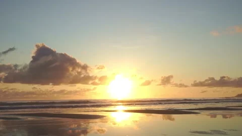 Wide Orange Sunrise on Beach with reflections and clouds, Static Stock Footage