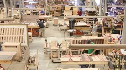Wide overhead shot of workers manufacture furniture at factory in U.S. Stock Footage