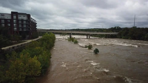 Wide Overhead view looking down at a swift fast moving, churning muddy clay brow Stock Footage 286852046