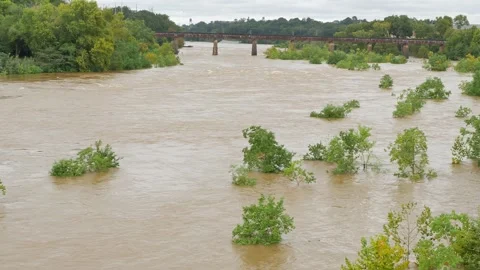 Wide Overhead view looking down at a swift fast moving, churning muddy clay brow Stock Footage 286853997