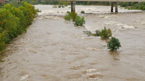 Wide Overhead view looking down at a swift fast moving, churning muddy clay brow Stock Footage 286854198