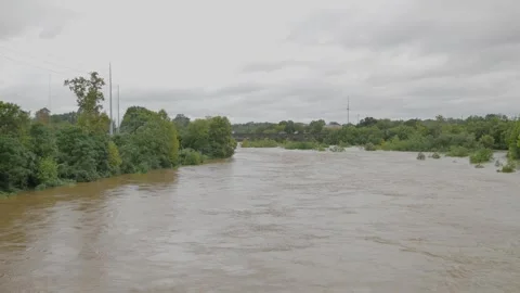 Wide Overhead view looking down at a swift fast moving, churning muddy clay brow Stock Footage 286855163