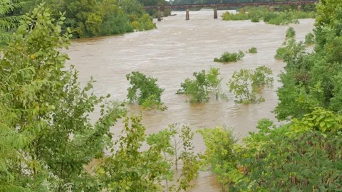 Wide Overhead view looking down at a swift fast moving, churning muddy clay brow Stock Footage 286855570