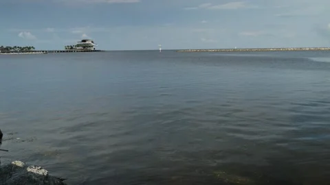 Wide pan left to right shot Demens Landing Park water towards pier and Tampa Bay Stock Footage 284046924