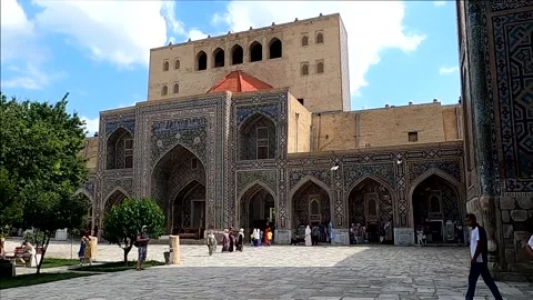Wide pan right of tourists visiting Registan Square in Samarkand Stock-Footage 336913549