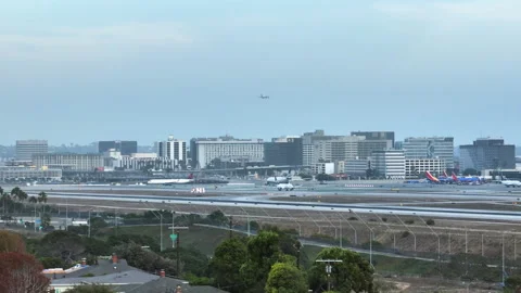 Wide pan shot of planes at cloudy LAX airfield with iconic control tower and Stock Footage 346675103