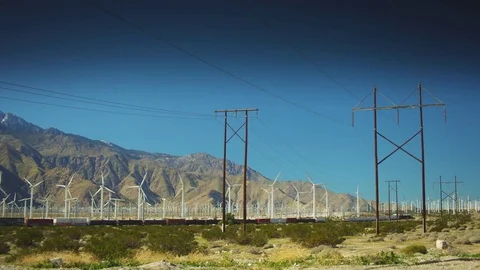 Wide Pan of A Train Passing Through a Wind Farm Stock Footage 75169855