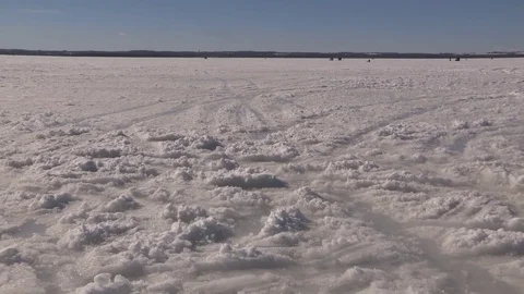 Wide Pan View of People out ice fishing and enjoying frozen lake Stock Footage 72690758